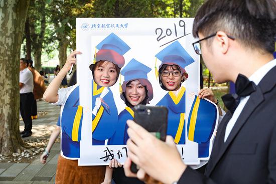 北京航空航天大学毕业生在“我们毕业了”拍照框前拍照。北京航空航天大学 宋超/摄